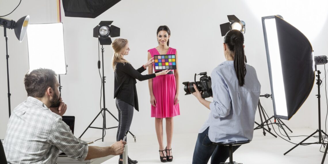 Photographer checking colour setting in white backdrop photography studio shoot